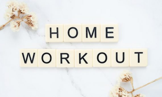 Stylish letter tiles spelling 'Home Workout' on a clean marble background with floral accents.